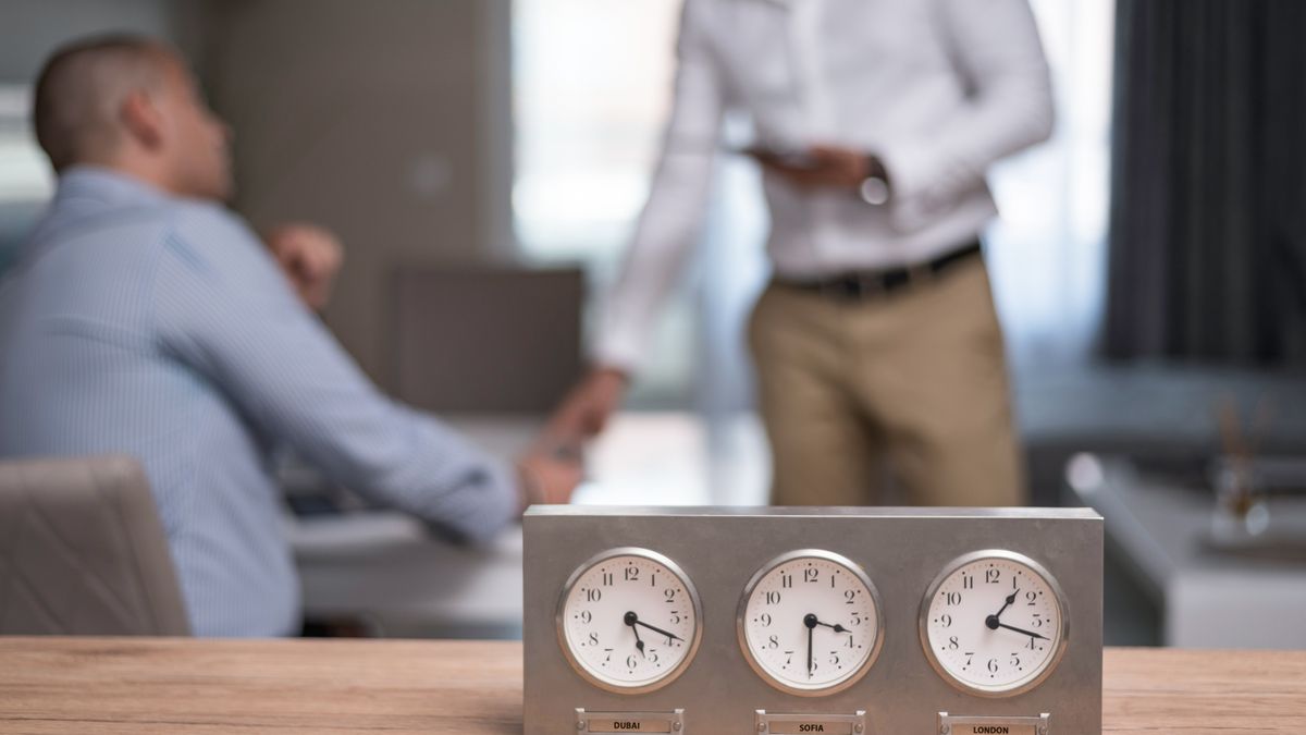 世界の時刻を確認しながら英語対応の予約システムを検討する様子