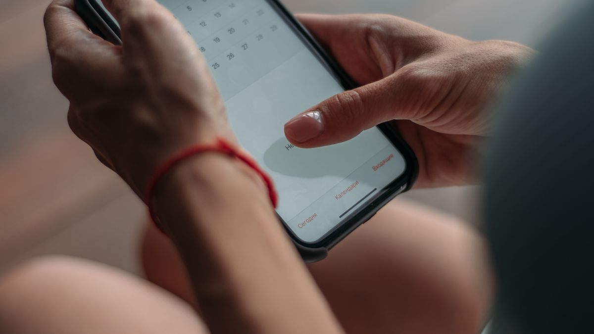 Hands booking a meeting slot from a smartphone calendar