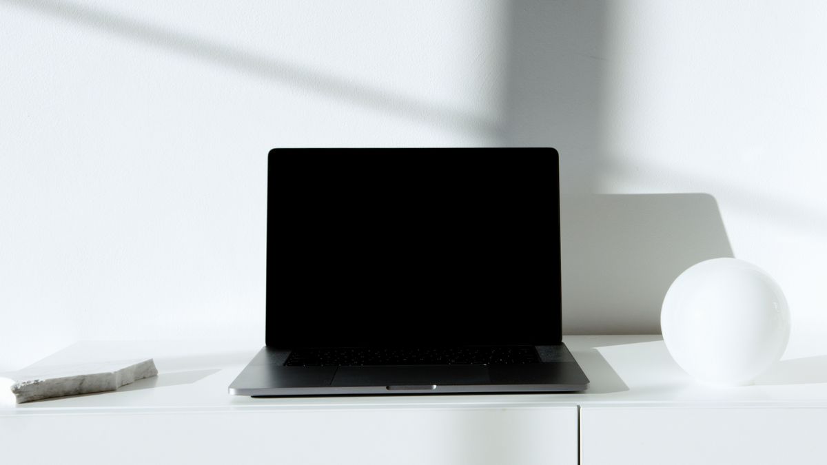 A laptop open on a desk showing an English admin interface — localising Calendly into Japanese