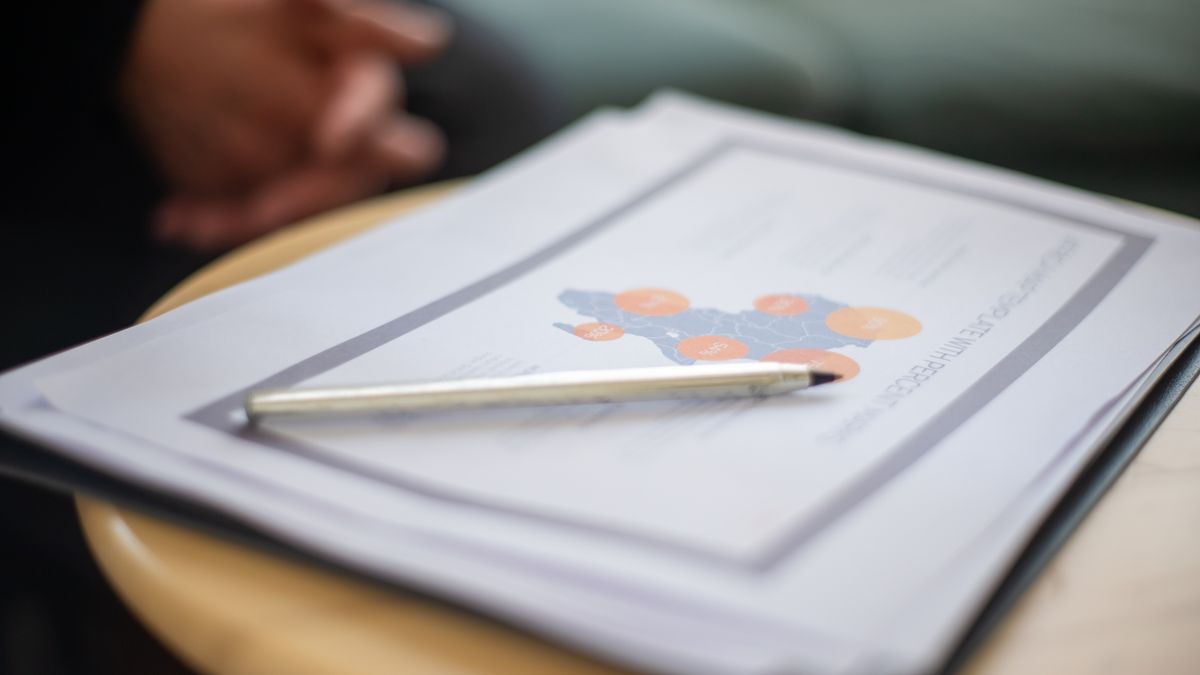 Printed documents and a pen on a desk, reviewing the rules for booking emails