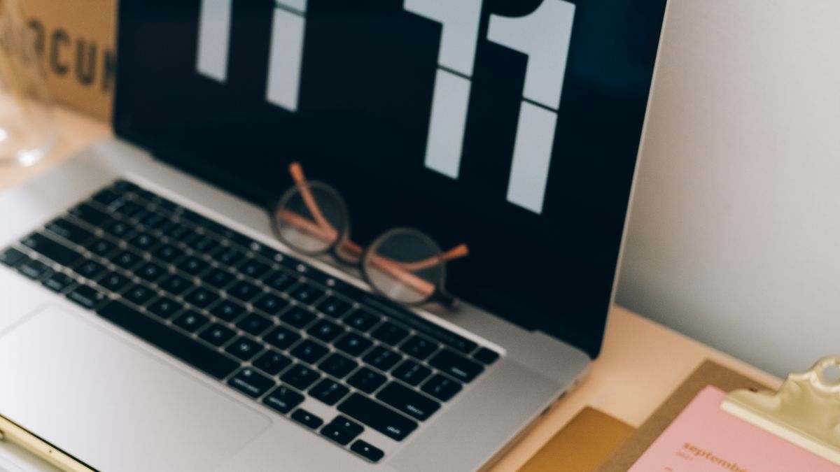 A laptop and calendar on a desk, used for scheduling in Teams and Outlook