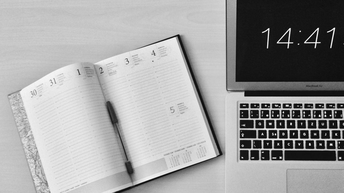 A notebook and laptop used to plan how external scheduling will work