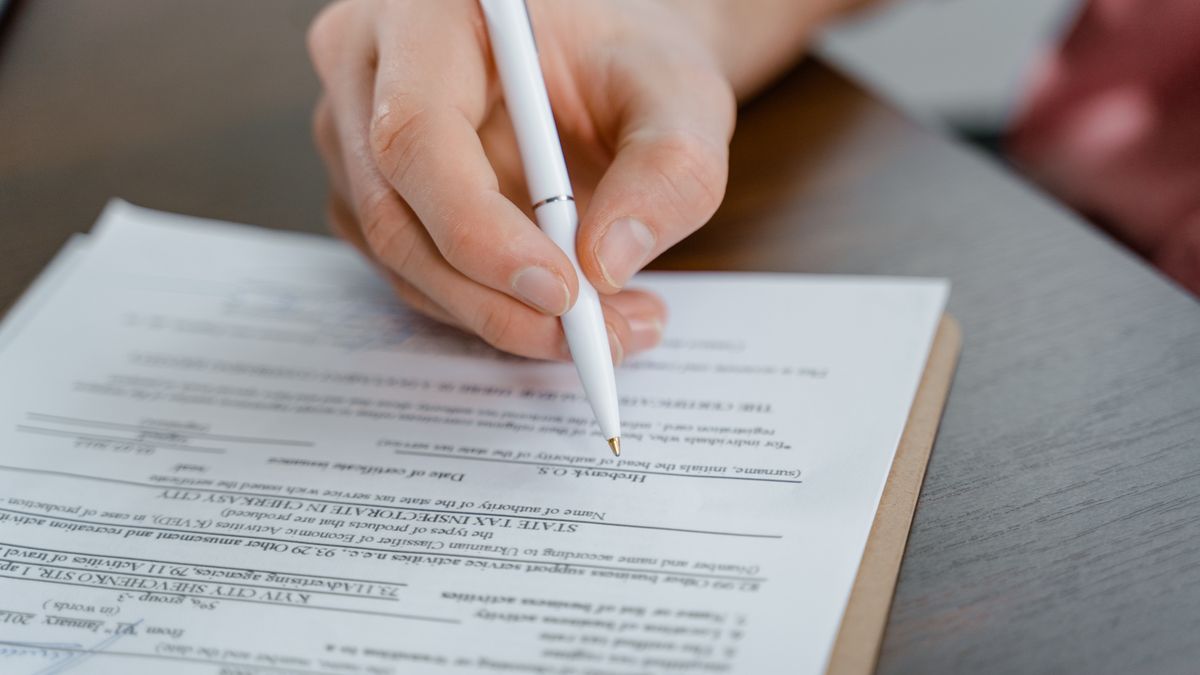 書類とペンを前に利用目的の記載を確認する手元