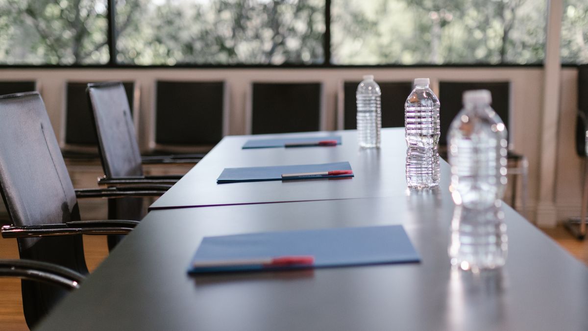 A meeting room schedule and notebook laid out on a desk