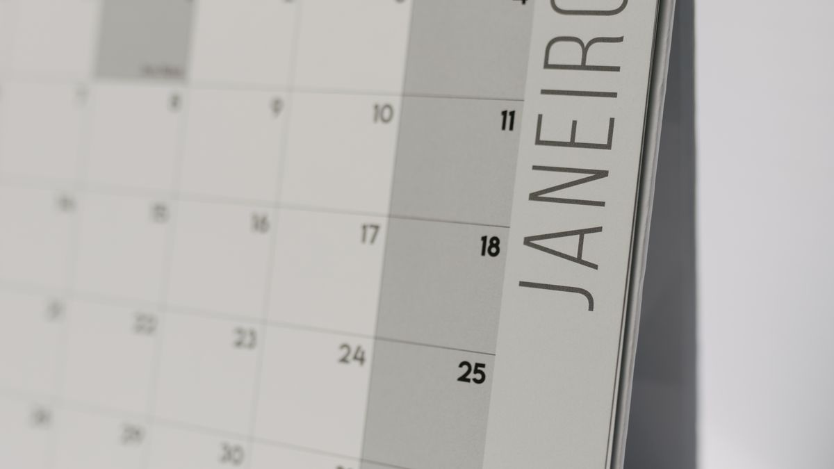 A desk and calendar set up for writing a scheduling email