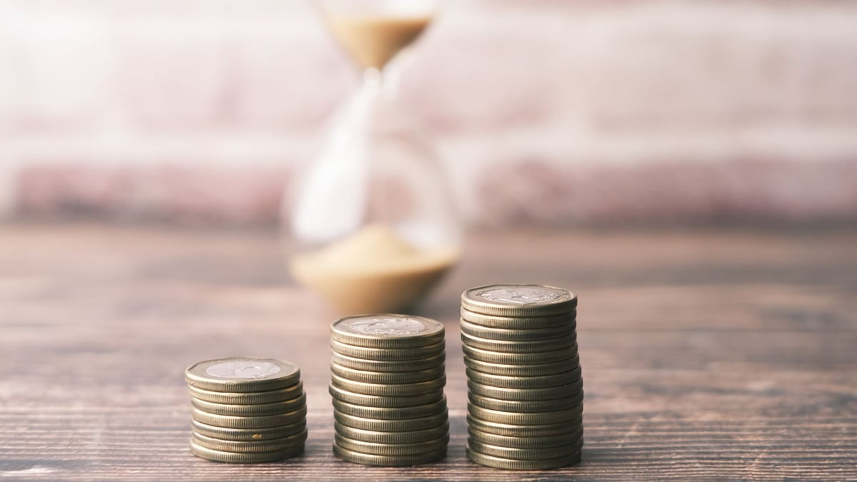 砂時計の前に積まれた硬貨。売上金には120日の申請期限がある