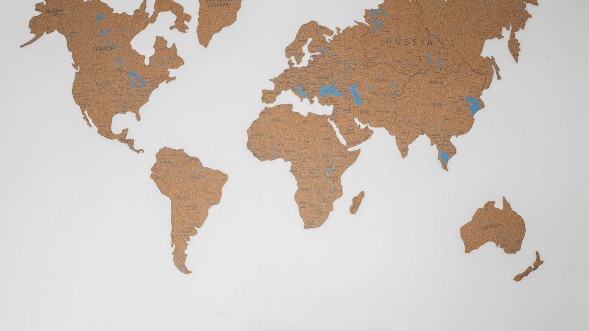壁の世界地図と整った机。Preplyで教える前に手数料と受け取り方を確認する